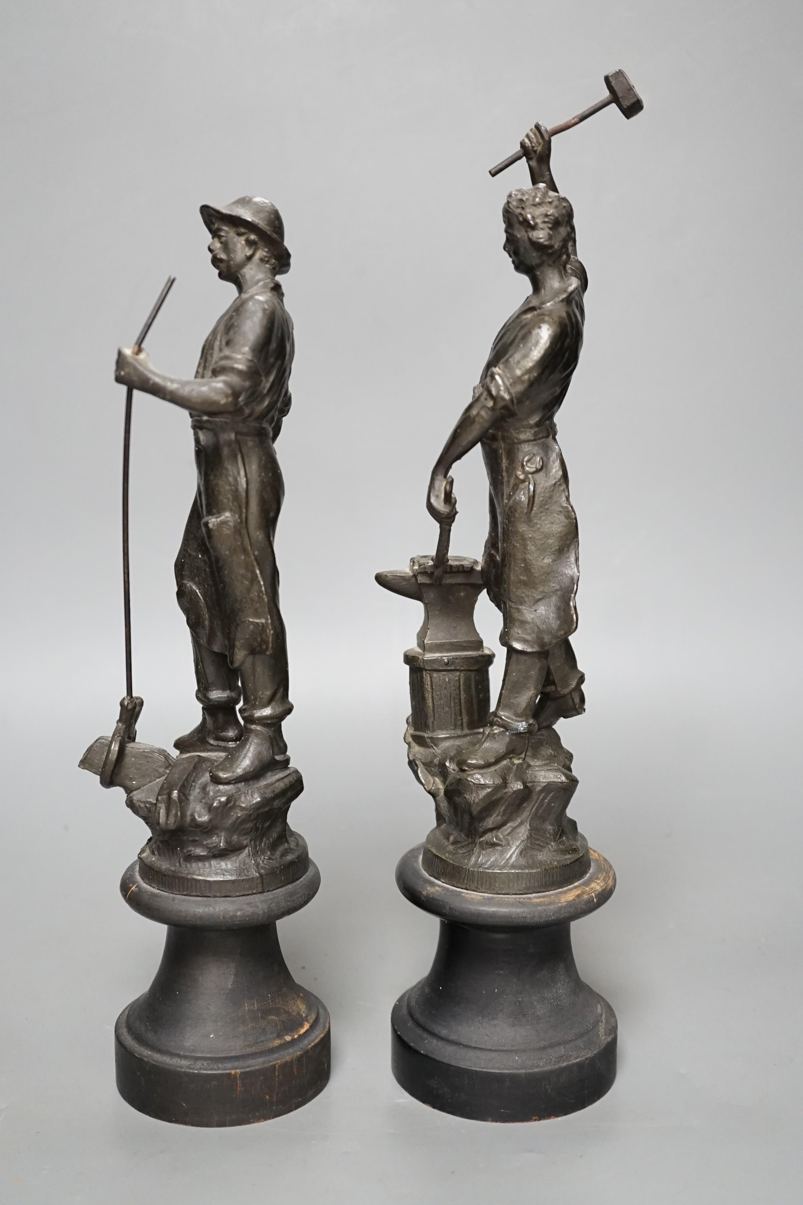 A pair of spelter blacksmith figures, tallest 34cms high